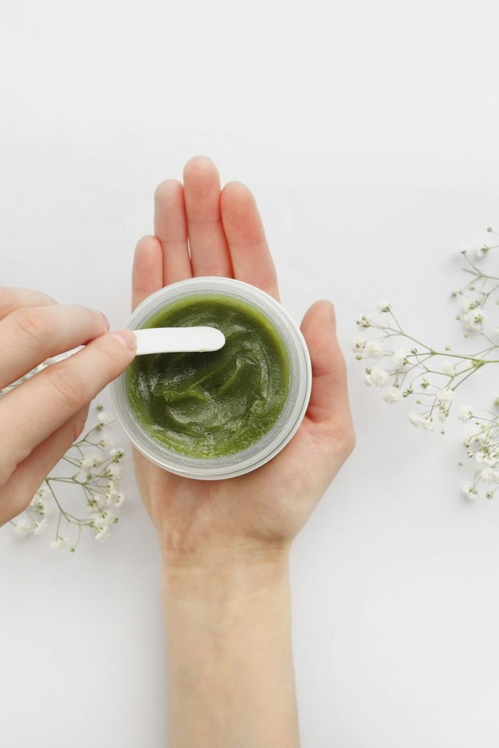 Young Female hands using green natural cream for face or body. organic natural skincare products